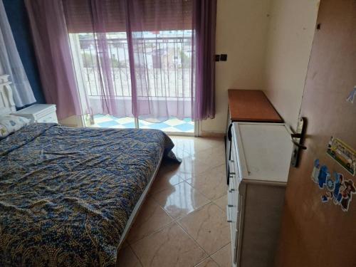 1 dormitorio con 1 cama, nevera y ventana en Élégance et Confort à Ain Sebaa, Commodité,Plages, en Casablanca