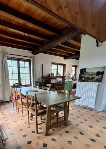 une salle à manger avec une table et des chaises en bois dans l'établissement La maison des bois à 10 minutes de Vezelay, à Montillot
