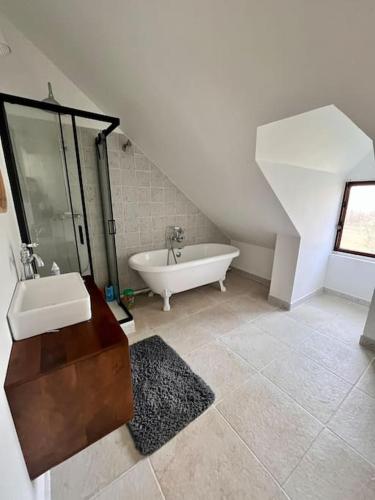 une salle de bain avec une baignoire et un lavabo dans l'établissement La maison des bois à 10 minutes de Vezelay, à Montillot