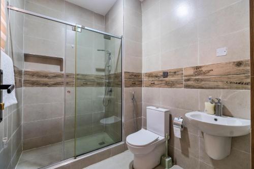 a bathroom with a toilet and a shower and a sink at Luxury Lagos Apartment with 3 Bedrooms in Lagos