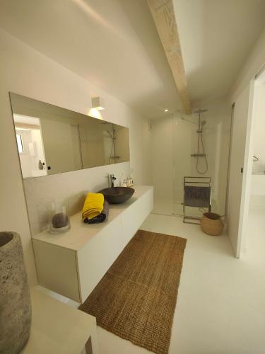 une salle de bain avec un lavabo et un miroir dans l'établissement La Maison l'Oliveraie, à Lunel