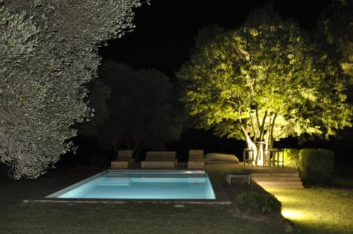 a swimming pool in the middle of a yard at night at La Maison l'Oliveraie in Lunel