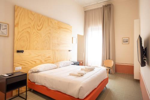 Un dormitorio con una cama grande con cabecero de madera. en Don Vittorio a Chiaia, en Nápoles