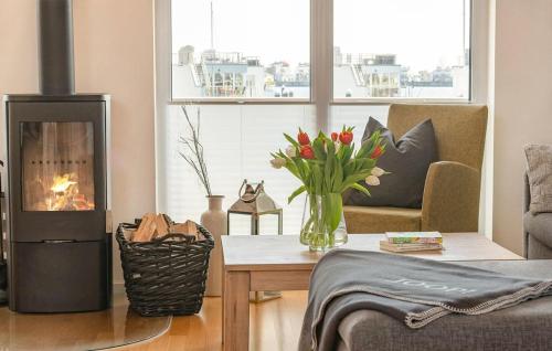 a living room with a fireplace and a table with flowers at Traumblick in Olpenitz