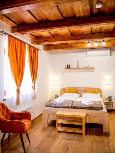 a bedroom with a bed and a table and a chair at Orgona Vendégház Golop in Golop