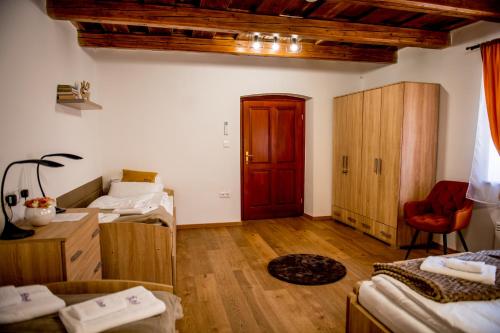a room with two beds and a red door at Orgona Vendégház Golop in Golop