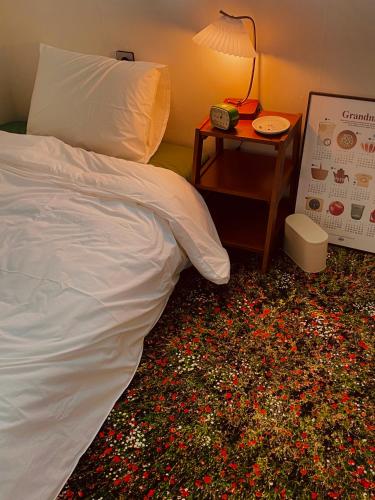 a bedroom with a white bed and a table with a lamp at Asla stay in Incheon