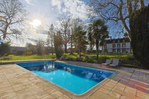 une piscine devant une maison dans l'établissement Le Manoir de Mousseaux, à Romorantin-Lanthenay