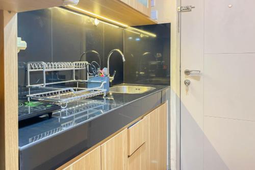 RawalembangにあるGood and Simply Studio Tokyo Riverside PIK 2 Apartment By Travelioのキッチン(カウンターに食器乾燥ラック付)