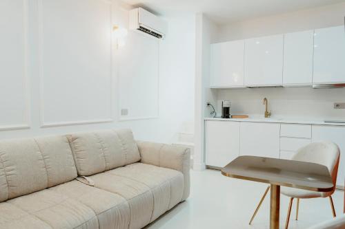 a white living room with a couch and a table at Luxury apartment-Quartieri Spagn by Alux38 in Naples