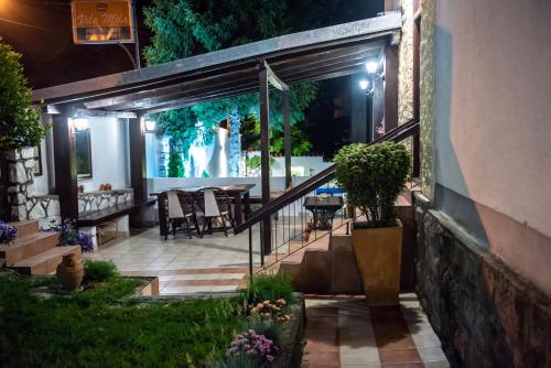 an outdoor patio at night with a table and chairs at Vila Mila in Arandjelovac