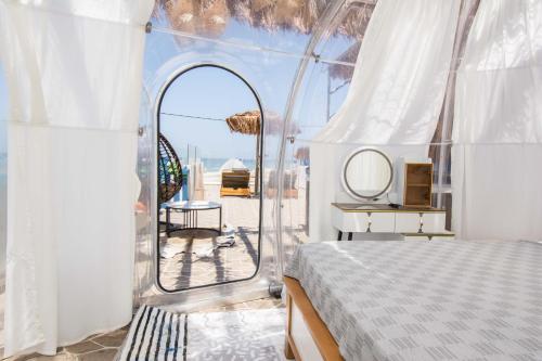 a bedroom with a bed and a view of the ocean at Gloo Glamping "by Checkin" in Analipsi