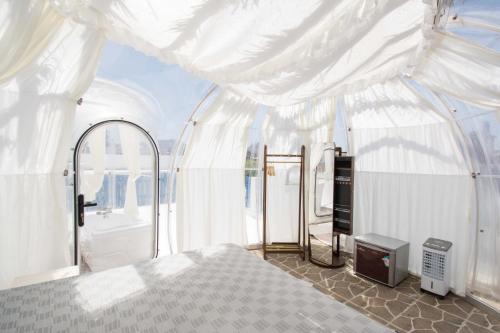 a white tent with a bed in a room at Gloo Glamping "by Checkin" in Analipsi
