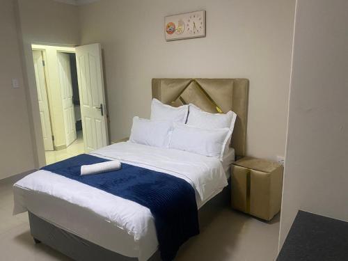 a bedroom with a bed with a blue and white blanket at Sabbath Lodge VIP in Cape Town