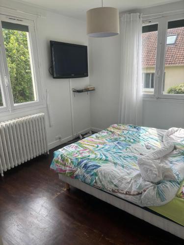 une chambre avec un lit et une télévision à écran plat dans l'établissement Le deauville, à Trouville-sur-Mer