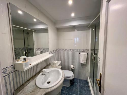 a white bathroom with a sink and a toilet at Portukoetxea - Basquenjoy in Hondarribia