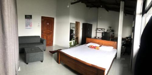 a bedroom with a bed and a chair at S V homestay in Kandy