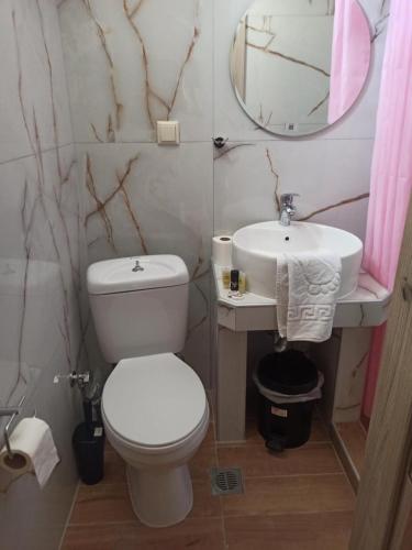 a bathroom with a white toilet and a sink at Amaya Pine Studio in Panayia
