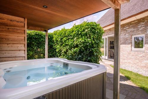 un jacuzzi en el patio trasero de una casa en Summio Buitenplaats de Marke van Ruinen, en Ruinen