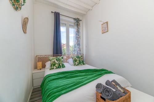 - une chambre avec un lit doté de draps verts et une fenêtre dans l'établissement R'Apparts Studio Little Nature, à Grenoble