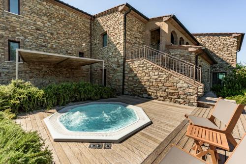 bañera de hidromasaje en una terraza frente a una casa en Villa Montioni by Mmega, en Casa Pallini