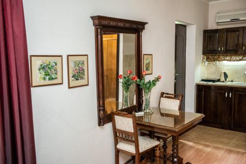 a dining room with a table and chairs and a kitchen at Vila Mila in Arandjelovac