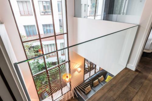- une vue depuis le 2ème étage d'un immeuble avec escalier en colimaçon dans l'établissement Bastille - Elegant duplex loft -6P, à Paris