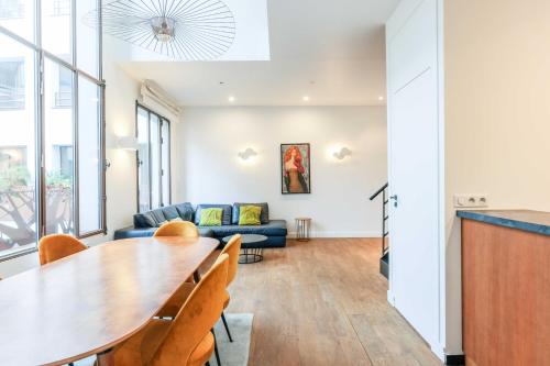 un salon avec une table et un canapé dans l'établissement Bastille - Elegant duplex loft -6P, à Paris