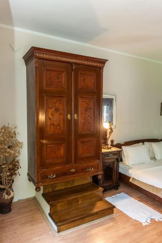 a bedroom with a wooden cabinet next to a bed at Vila Mila in Arandjelovac
