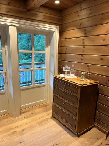 a room with a wooden wall and a wooden dresser at Jostedal Lodge in Jostedal