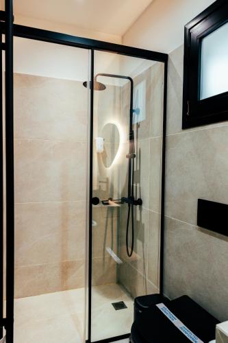 a shower with a glass door in a bathroom at Mikelina Boutique Hotel in Pallíni