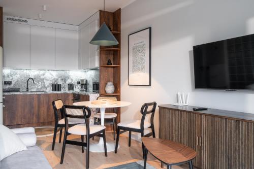 a living room with a table and chairs and a kitchen at RentPlanet - Kępa Mieszczańska in Wrocław