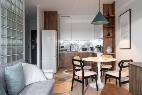 a kitchen and a living room with a table and chairs at RentPlanet - Kępa Mieszczańska in Wrocław