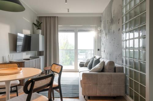 a living room with a couch and a table at RentPlanet - Kępa Mieszczańska in Wrocław
