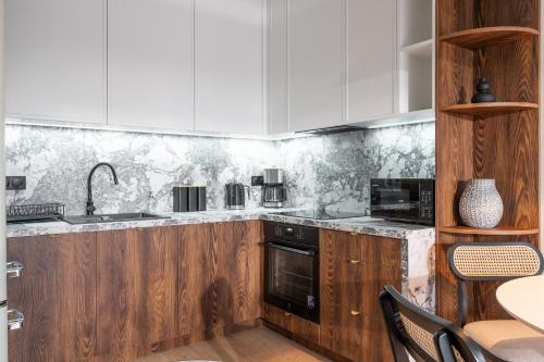 a kitchen with wooden cabinets and a counter top at RentPlanet - Kępa Mieszczańska in Wrocław