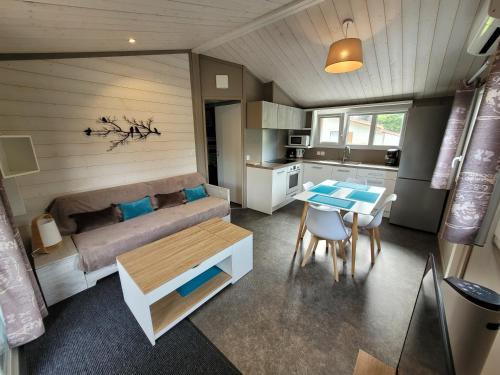Cette chambre dispose d'un canapé, d'une table et d'une cuisine. dans l'établissement Chalet familial entre lac et fôret, à Azur