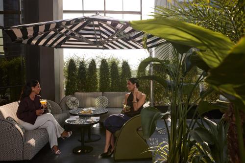 two women sitting on couches on a patio at Four Seasons Hotel Dubai International Financial Centre in Dubai
