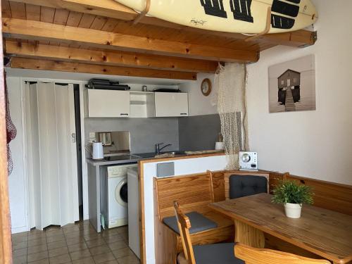 une cuisine avec une table et une salle à manger avec une planche de surf dans l'établissement Eden, à Leucate