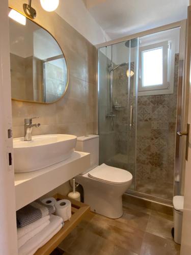 a bathroom with a toilet and a sink and a shower at Nostos in Patitiri