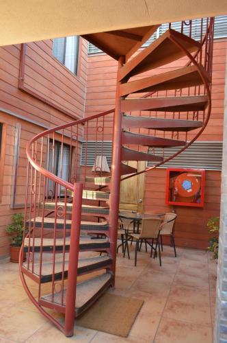 a spiral staircase in a patio with a table at Hotel Cumbres de Atacama in Copiapó