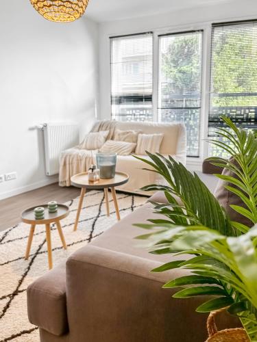 un salon avec un canapé et deux tables dans l'établissement Charme et confort à Bondy - proche Paris Disney CDG, à Bondy