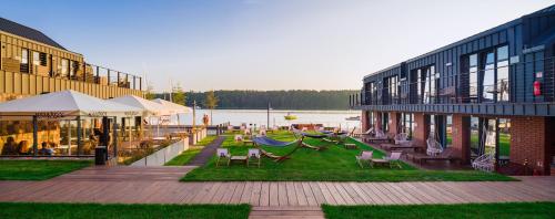 a patio with chairs and a hammock next to a building at Kurort Kameralny in Mikołajki