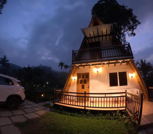 ein kleines Haus mit Lichtern in der Nacht in der Unterkunft Hill View 'A'Frame Villa Wayanad in Vythiri