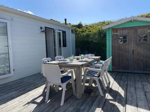 a wooden table and chairs on a deck at Summer house on the Dutch coast in IJmuiden
