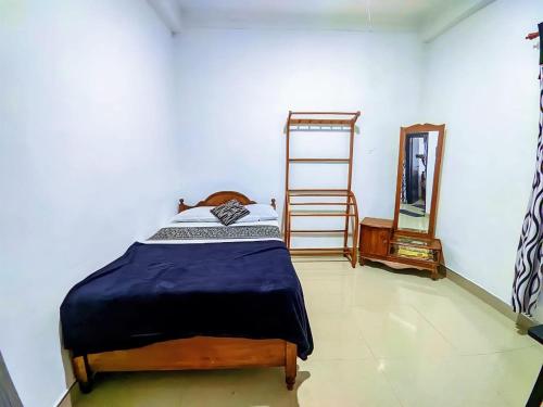a bedroom with a bed and a mirror at White Home in Haputale
