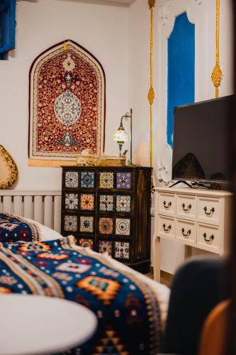 a bedroom with a bed and a dresser with a tv at 寻疆别苑民宿 Kashgar Ancient City Scenic Area in Kashgar