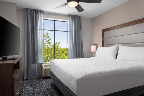 a hotel room with a bed and a large window at Homewood Suites by Hilton Hartford South-Glastonbury in Glastonbury