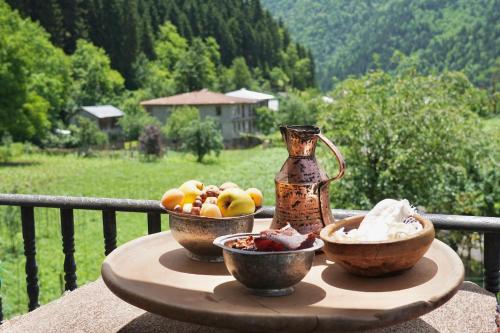 a table with two bowls of fruit and a vase at Guesthouse Mareti in Shuakhevi