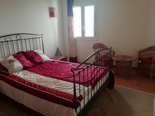 - une chambre avec un lit doté de draps rouges et une fenêtre dans l'établissement Appartement face au quai d'honneur, à Calvi