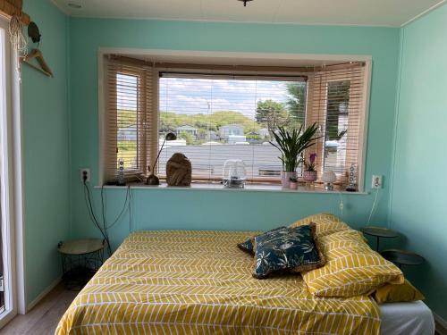 a bedroom with a bed and a large window at Summer house on the Dutch coast in IJmuiden